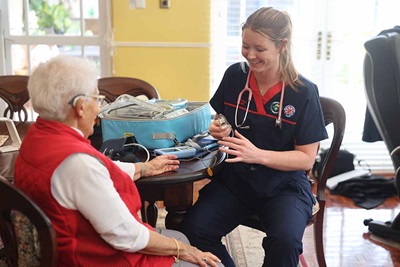 Nurse caring for elderly patient on their own home