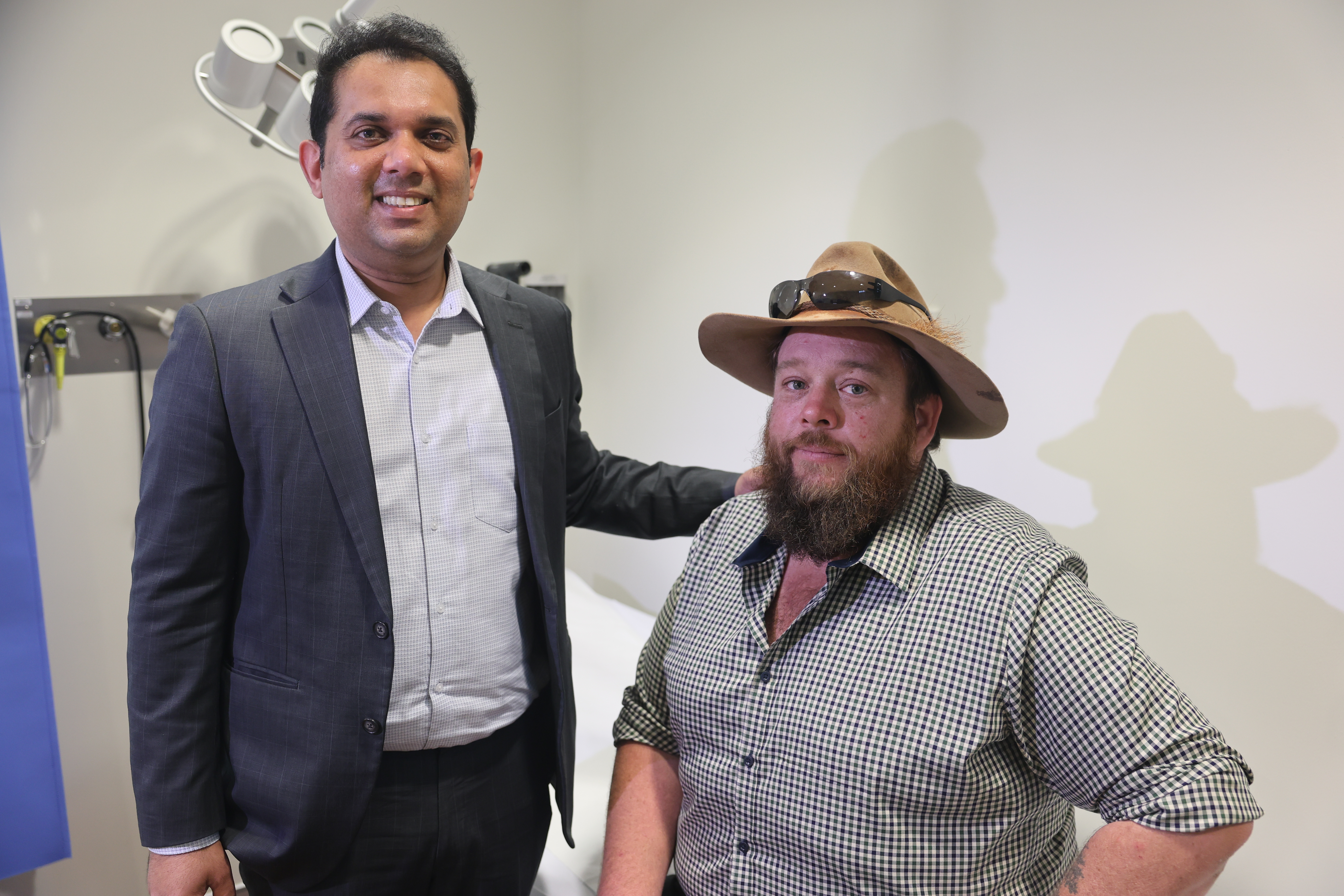 Medical Oncologist at SCGH Dr Rajiv Shinde standing beside patient Brodie Sawyer who is seated.
