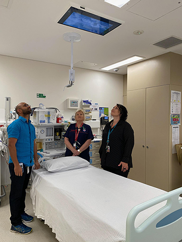 Mr Eldhose Baby, A/ Nurse Manager; Julie Reynolds, Clinical Nurse; and Dannielle Orifici, Coordinator of Nursing, Mental Health viewing the newly installed ceiling screen.